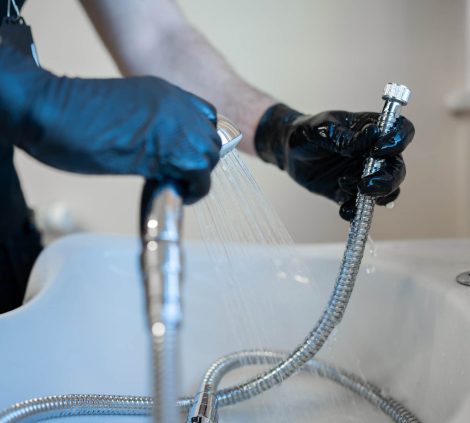 Legionella risk assessment technician testing shower head flow and temperature