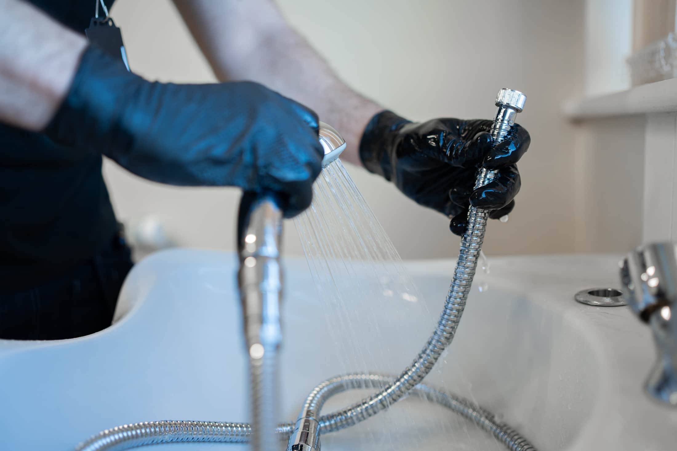 Legionella risk assessment technician testing shower head flow and temperature
